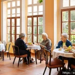 요양병원 식사 품질 후기 - A warm, inviting dining room in a Spanish elderly care residence during lunchtime, featuring natural...